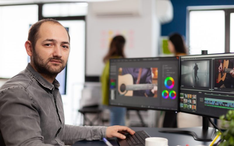 videographer-looking-camera-smiling-working-creative-startup-workplace_11zon videographer-looking-camera-smiling-working-creative-startup-workplace_11zon